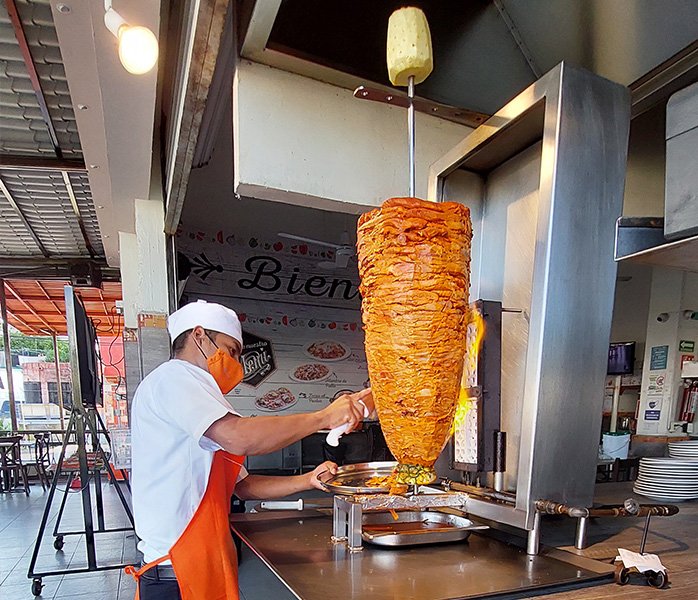 tacos-en-diamante-rebanando-carne-al-pastor hombre rebanando carne al pastor para tacos en Diamante