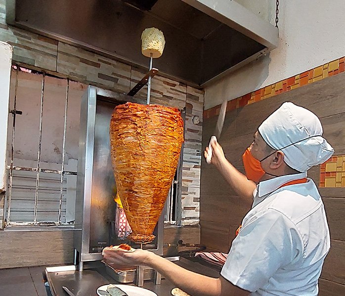 tacos-a-domicilio-en-costa-azul-trompo-carne-al-pastor taquero preparando tacos a domicilio en Costa Azul Acapulco