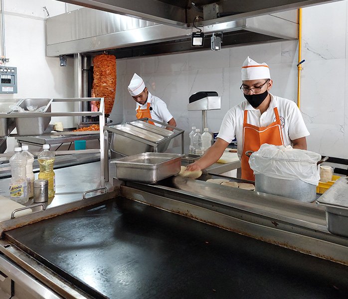 tacos-a-domicilio-en-acapulco-plancha hombre en la plancha cocinando tacos para domicilio en Acapulco