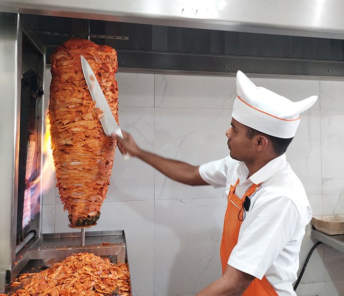 tacos-a-domicilio-en-acapulco-carne-al-pastor taquero preparando tacos para repartir a domicilio desde la sucursal Fórum Express en Acapulco