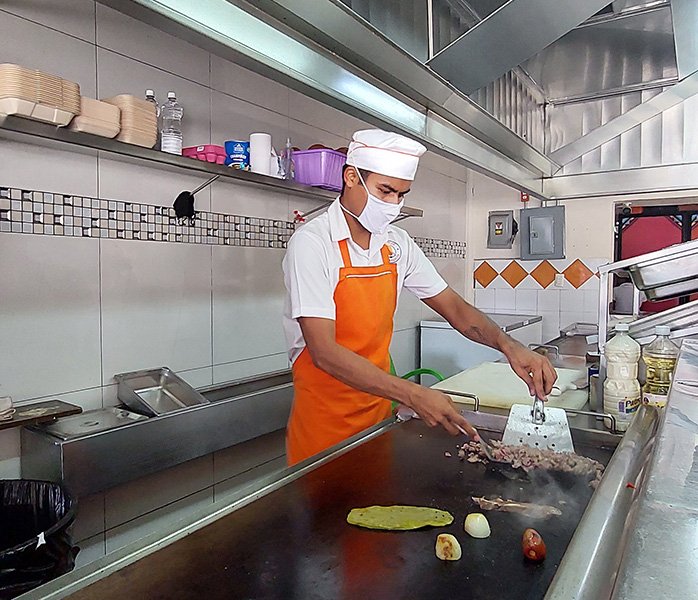 tacos-a-domicilio-en-acapulco-plancha-platillos Hombre cocinando tacos para servicio a domicilio en Acapulco