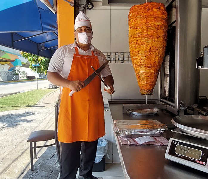 tacos-en-forum-acapulco-trompo-carne-al-pastor taquero con cuchillos para preparar tacos en Forum Acapulco